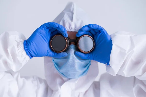 Mulher médico em um terno protetor mantém-se a óculos — Fotografia de Stock