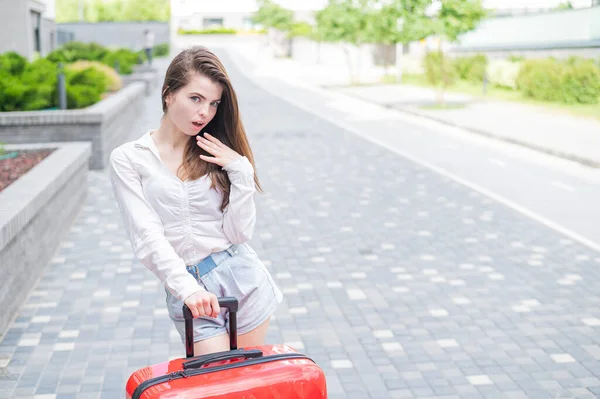 一个漂亮的高加索女人带着一个大行李箱走在街上。3.那女孩出去度假了 — 图库照片