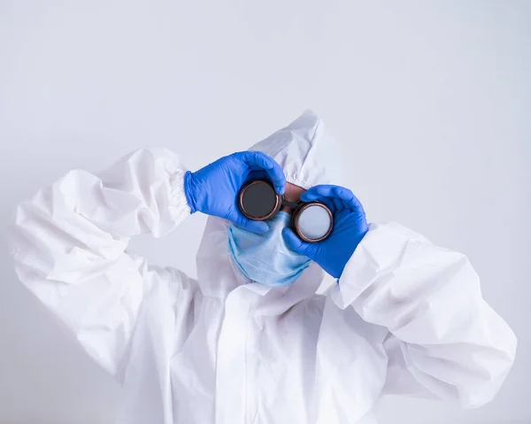 Mujer doctora en traje de protección se aferra a las gafas — Foto de Stock