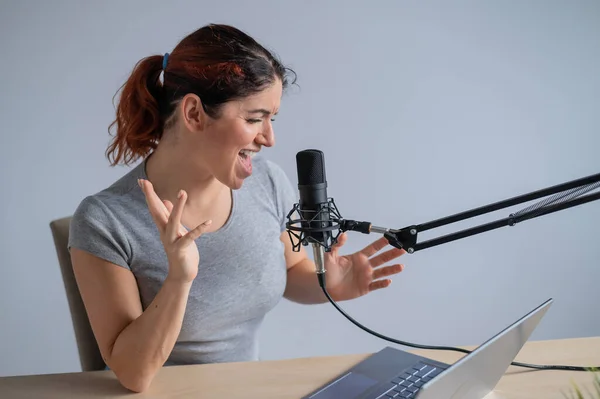 Uma encantadora apresentadora de rádio está transmitindo ao vivo em um laptop. Conceito de rádio online — Fotografia de Stock