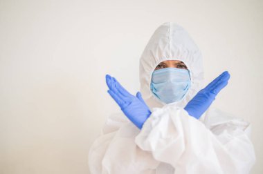 Koruyucu giysili kadın doktor kollarını kavuşturmuş. Koronavirüsü durdurun.