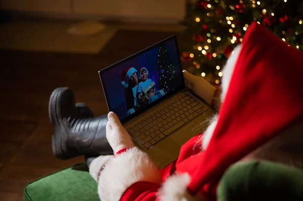 Szczęśliwa mama i syn rozmawiają z Mikołajem przez video czat na laptopie. Kobieta i chłopiec zdalnie życzy Wesołych Świąt — Zdjęcie stockowe