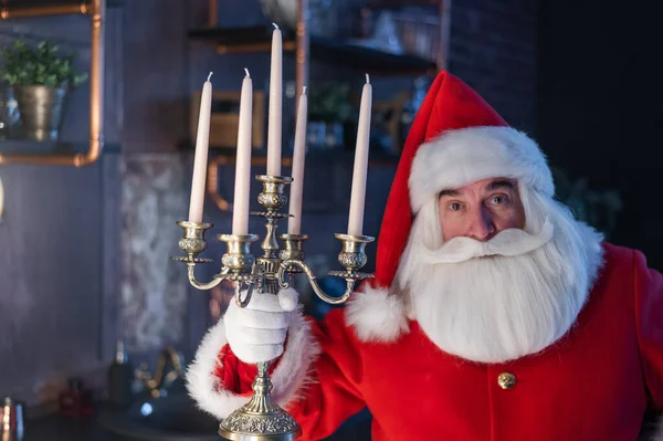 Santa Claus se acerca por la noche y sostiene un candelabro. — Foto de Stock