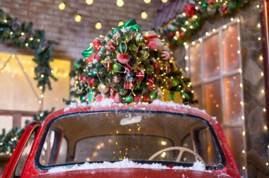 Açık havada kırmızı klasik bir arabada Noel ağacı. Madalyalı Noel Baba arabası.