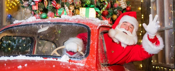 Santa Claus cumprimentando enquanto dirige um carro retro vermelho. Feliz Natal. Widescreen. — Fotografia de Stock