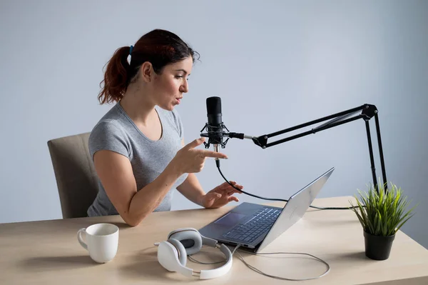 Eine charmante Radiomoderatorin überträgt live auf einem Laptop. Online-Radiokonzept — Stockfoto