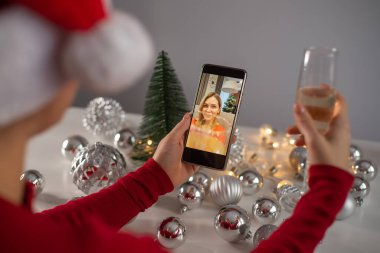 Kadınlar cep telefonuyla video görüşmesi yaparlar. Kızlar Noel 'i kutlamak için şampanya içerler ve akıllı telefonla uzaktan iletişim kurarlar.