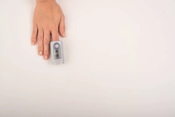 Main féminine avec un appareil de mesure saturation. Teneur en oxygène du sang dans le coronavirus — Photo