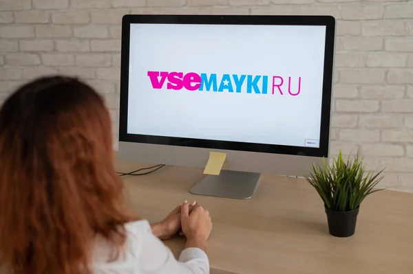女性がモニターにvsemaykiのロゴとコンピュータに座っている — ストック写真