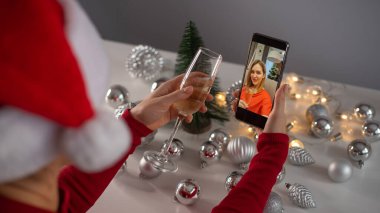 Kadınlar cep telefonuyla video görüşmesi yaparlar. Kızlar Noel 'i kutlamak için şampanya içerler ve akıllı telefonla uzaktan iletişim kurarlar.