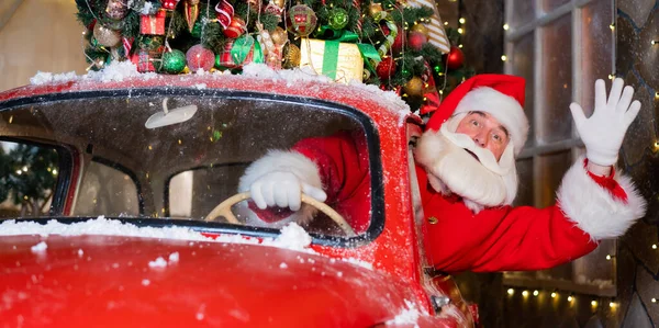Санта Клаус здоровается за рулём красной ретро-машины. Счастливого Рождества. Широкоэкранный. — стоковое фото