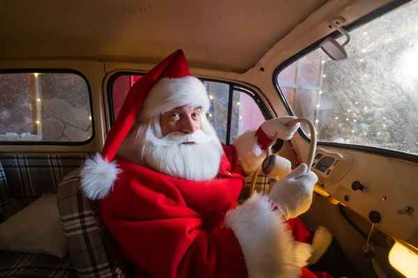 Портрет Санти Клауса за кермом автомобіля, завантаженого ялинкою та подарунками — стокове фото