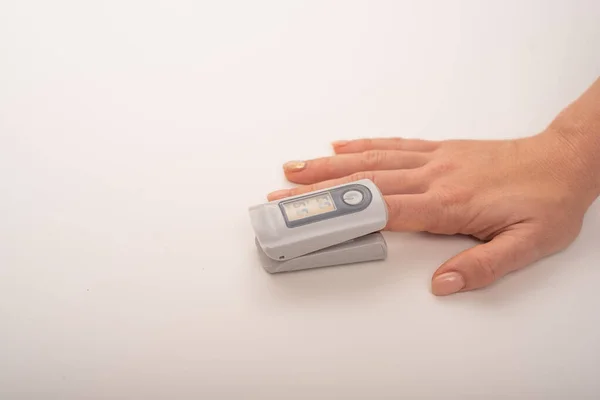 Female hand with a measuring device saturation. Blood oxygen level in coronavirus — Stock Photo, Image