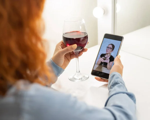 Жінки розмовляють через відеозв'язок по телефону і п'ють червоне вино. Карантинна дівчина не робить відеодзвінок — стокове фото
