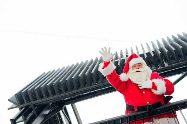 Санта Клаус дивиться вниз зі сходів і бажає веселої креми на відкритому повітрі. — стокове фото