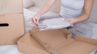 Beyaz bir kadın yatakta otururken sipariş veriyor. Ev teslimatıyla online alışveriş kavramı