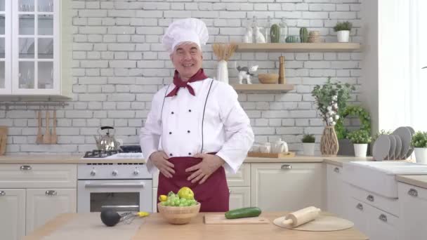 Starszy mężczyzna kucharz pozowanie w kuchnia — Wideo stockowe