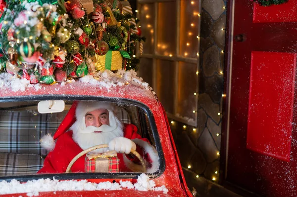 Retrato de Papai Noel dirigindo um carro vermelho e entregando presentes para o Natal — Fotografia de Stock