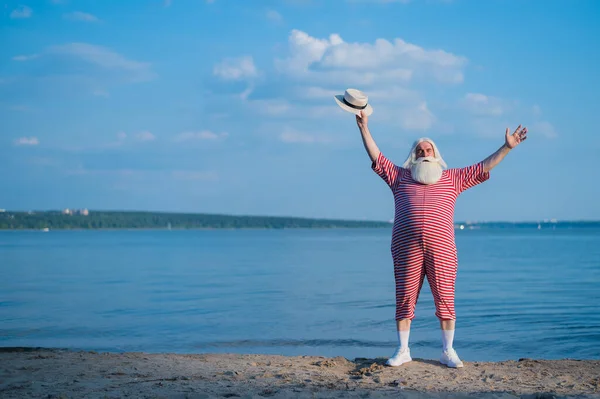 海岸沿いの縞模様のレトロな水着の老人 — ストック写真