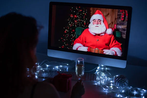 Kobieta zdalnie rozmawiająca ze Świętym Mikołajem na rozmowie wideo na twoim komputerze. Mężczyzna przebrany za Świętego Mikołaja gratuluje swojej dziewczynie świąt. Koncepcja nowego roku 2021. — Zdjęcie stockowe