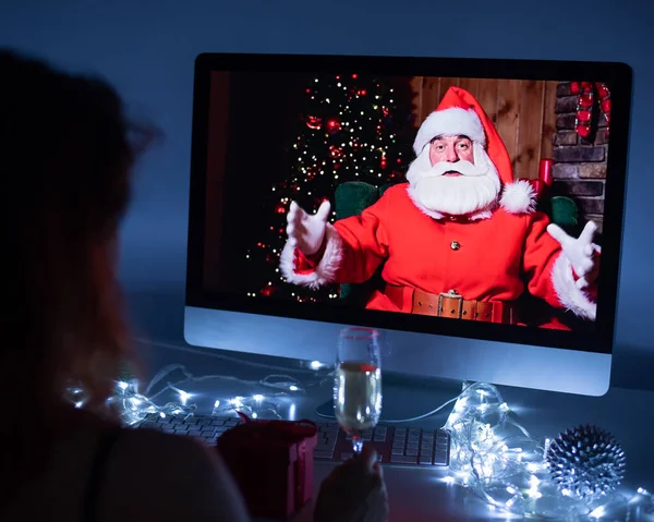 Femme parlant à distance avec le Père Noël lors d'un appel vidéo sur votre ordinateur. Un homme déguisé en Père Noël félicite sa petite amie pour Noël. 2021 nouvelle année concept. — Photo