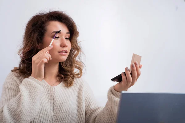 Online training for make-up. A woman teacher explains the makeup application scheme on the air