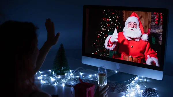 Femme parlant à distance avec le Père Noël lors d'un appel vidéo sur votre ordinateur. Un homme déguisé en Père Noël félicite sa petite amie pour Noël. 2021 nouvelle année concept. — Photo