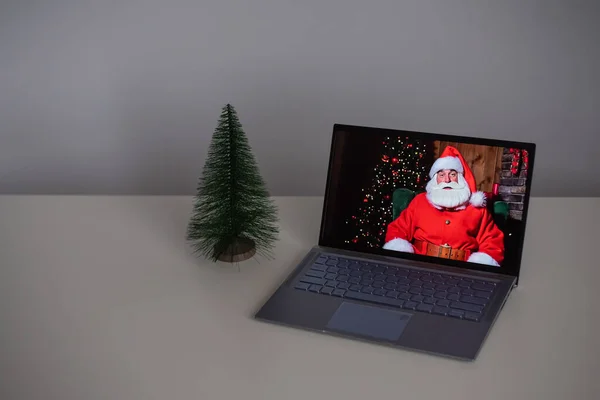 Père Noël souhaite Joyeux Noël par appel vidéo sur un ordinateur portable. Communication à distance — Photo