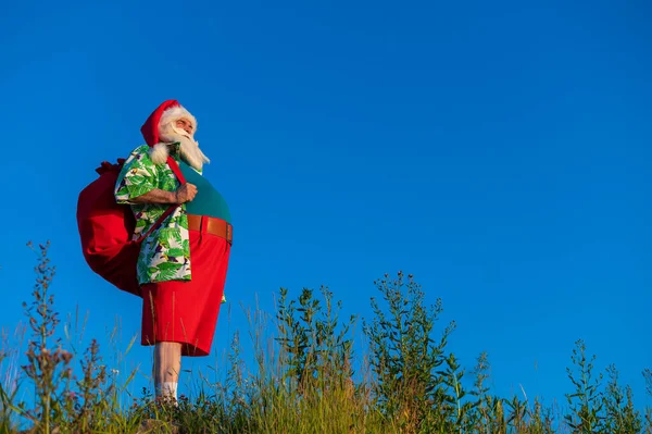 Babbo Natale in camicia hawaiana cammina nella natura. Natale ai tropici — Foto Stock