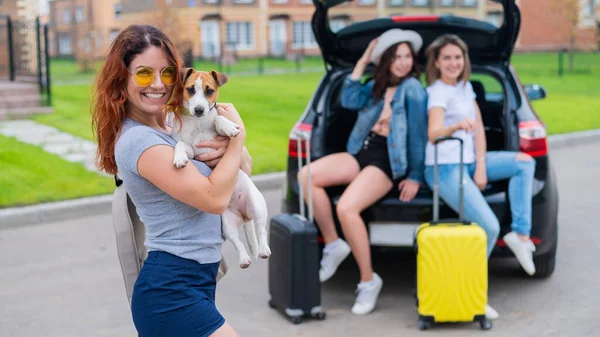快乐的三个女人在车里鬼混.女朋友们带着狗开车旅行 — 图库照片