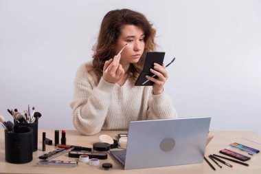 Makyaj için çevrimiçi eğitim. Bir kadın öğretmen canlı yayında makyaj uygulamasını açıklıyor.