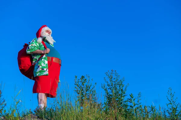 Babbo Natale in camicia hawaiana cammina nella natura. Natale ai tropici — Foto Stock