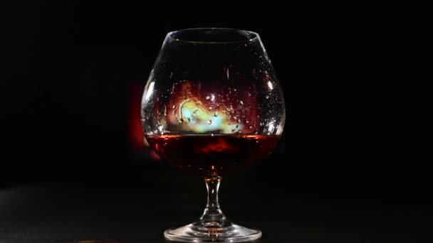 Een glas cognac en sigarenrook in het donker op de achtergrond van de open haard. Herenclubconcept — Stockvideo