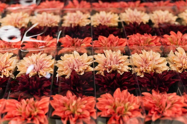 Květináče s umělými květinami v obchodě. Identické plastové rostliny — Stock fotografie