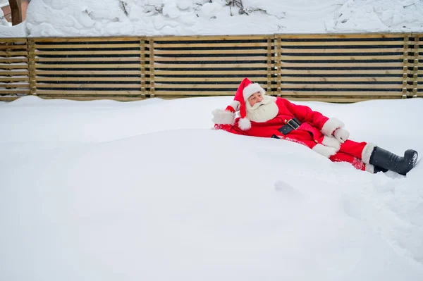 Lycklig tomte som ligger i snön och skojar — Stockfoto