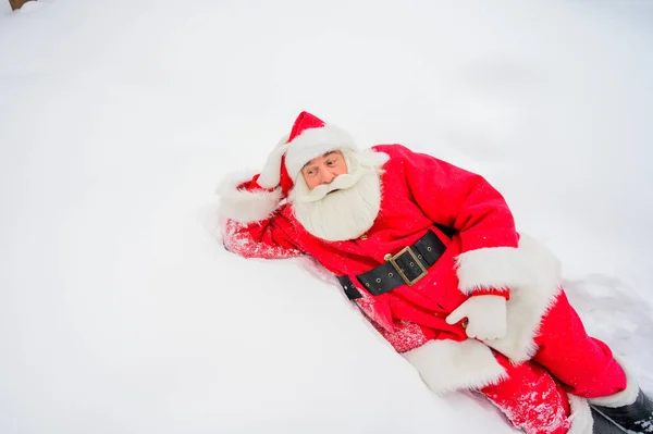 Heureux Père Noël claus couché dans la neige et de s'amuser autour — Photo