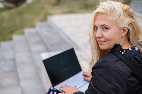 보청기를 갖춘 금발 여자 가집 밖 노트북에 앉아 있다. — 스톡 사진