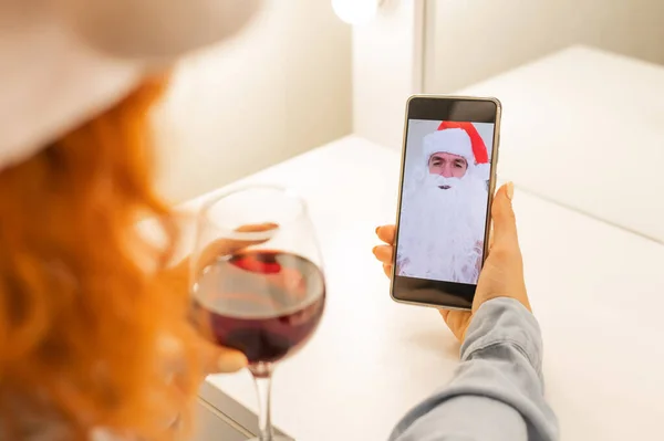 Mujer hace una videollamada a Santa Claus y bebe vino tinto en Navidad —  Fotos de Stock