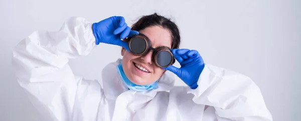 Mujer doctora en traje de protección se aferra a las gafas —  Fotos de Stock