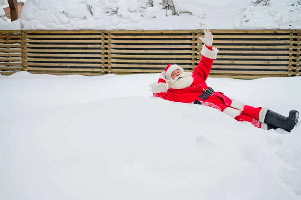Lycklig tomte som ligger i snön och skojar — Stockfoto