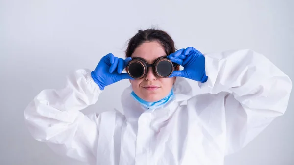 Ärztin im Schutzanzug hält an Brille fest — Stockfoto
