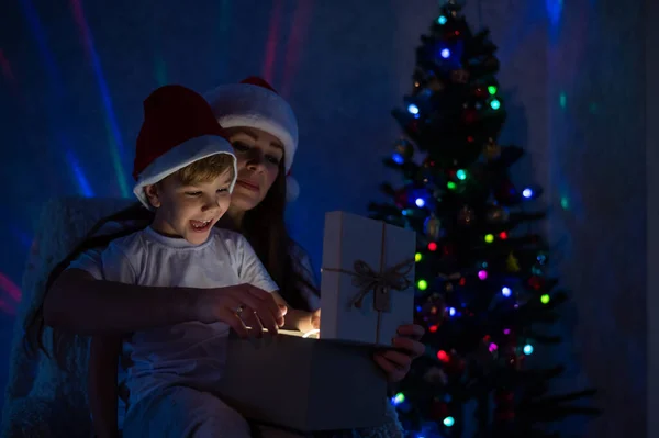 Mère et fils excitants ouvrent une boîte-cadeau éclatante lors d'une nuit de Noël magique — Photo