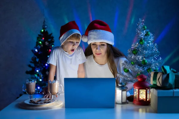 Щаслива мама і син розмовляють на відеодзвінок на ноутбук в різдвяну ніч . — стокове фото