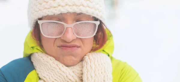 Retrato de uma mulher em óculos cobertos de geada. Menina perturbada congelando em tempo muito frio ao ar livre. Widescreen. — Fotografia de Stock