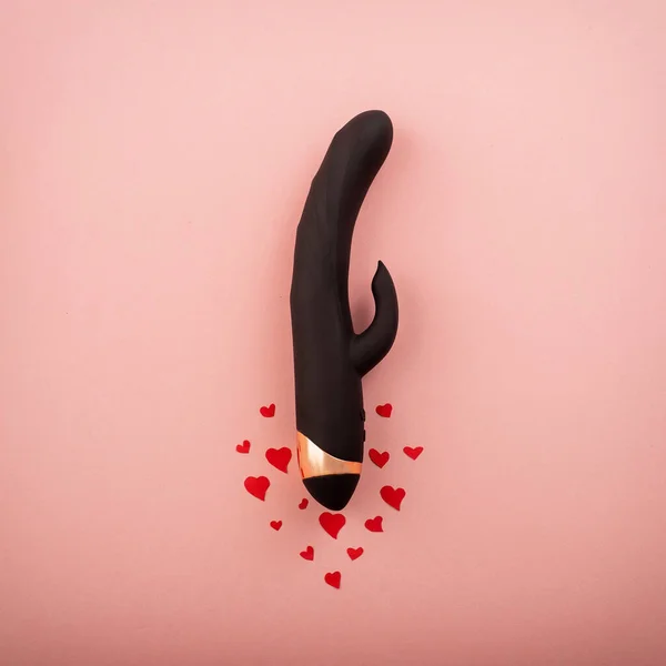 Gode vaginal clitoridien noir et les cœurs sur un fond rose. vibromasseur féminin comme cadeau pour la Saint-Valentin — Photo