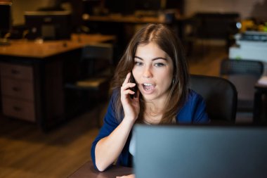 İş yerinde cep telefonuyla konuşan güzel beyaz bir kadın. Ofiste bir iş kadınının portresi.