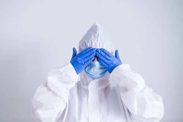 Žena v ochranném obleku a lékařské masce si zakryje oči rukama. Já nevidím zlo. — Stock fotografie