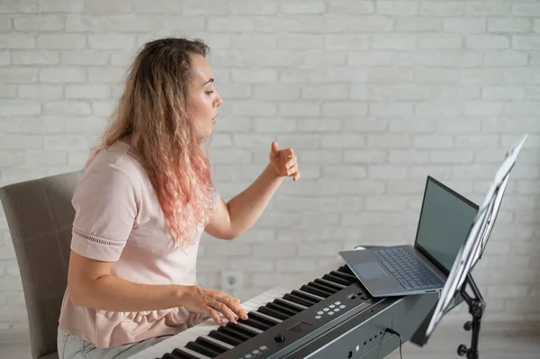 Musikunterricht aus der Ferne. Ein Gesangslehrer zeichnet den Unterricht mit einer Laptop-Webcam auf. — Stockfoto