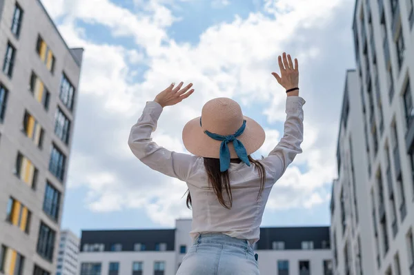 Vista trasera de una mujer en un sombrero sentado en el fondo de la ciudad —  Fotos de Stock