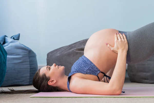 Gravid kaukasiska kvinna på fitness med en boll. Yoga för blivande mödrar. Flicka i klassrummet som förberedelse för förlossning. Pilates under den sista trimestern. — Stockfoto